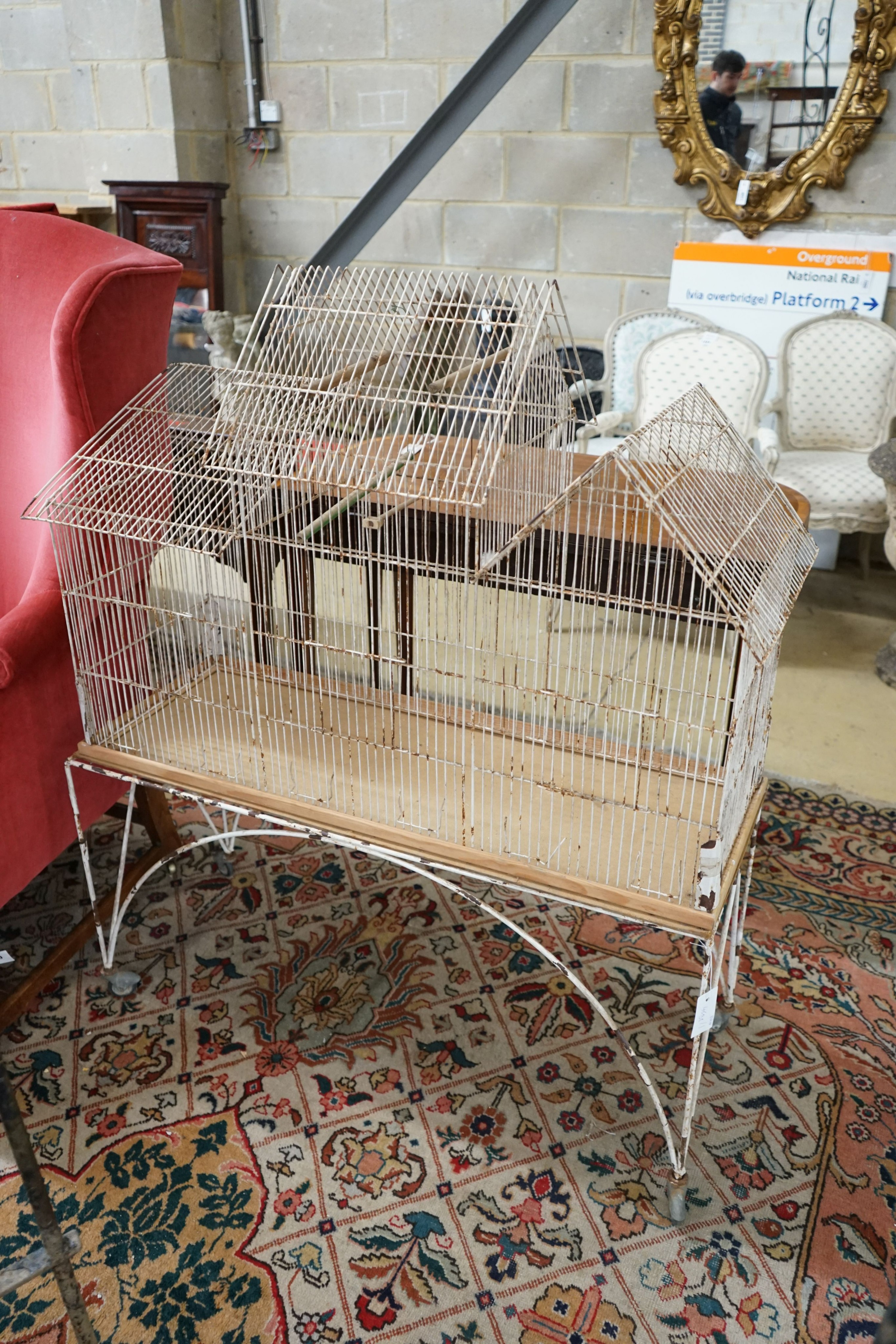 A painted wirework bird cage on stand, width 99cm, depth 36cm, height 117cm